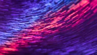 A vibrant abstract long-exposure photograph of swirling light trails, creating a dynamic vortex of bright purple, blue, and pink neon colors.